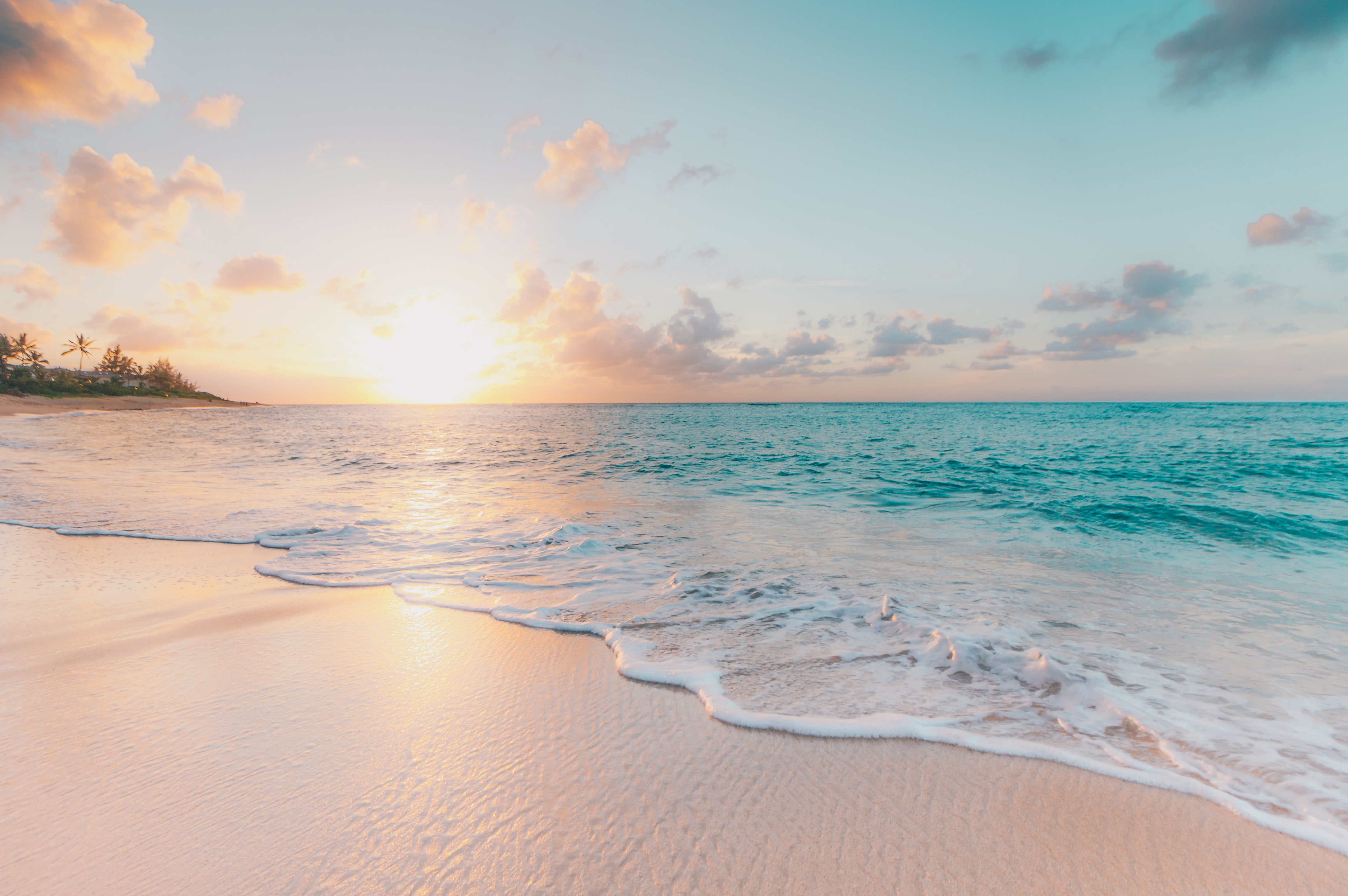 Sunset over the beach as the waves roll in.